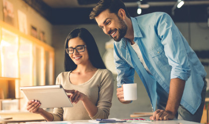 Couple of designers is using a digital tablet.